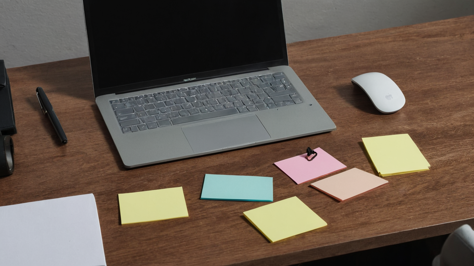 Blank sticky notes beside dark laptop